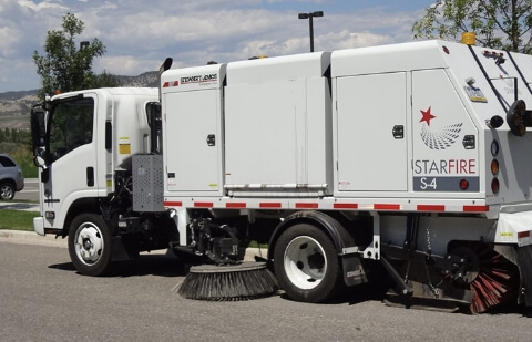 Stewart-Amos Starfire S-4 Mechanical Broom sweeper operating on a road